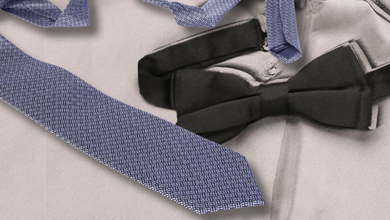 A close-up of a formal clothing ensemble featuring a textured dark blue tie, a black bow tie, and parts of a gray dress shirt. The ties contrast with the smooth fabric of the shirt.
