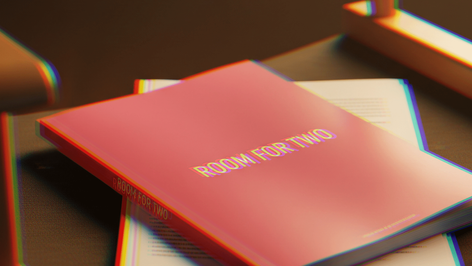 A script titled ROOM FOR TWO rests on top of a white book on a dark surface, partially under a lamp.